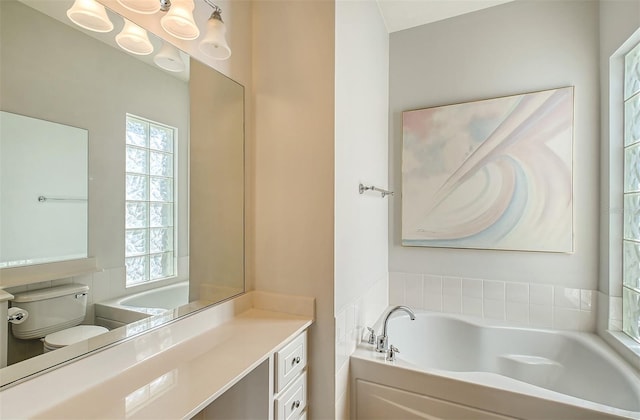 bathroom featuring vanity, toilet, and a bath