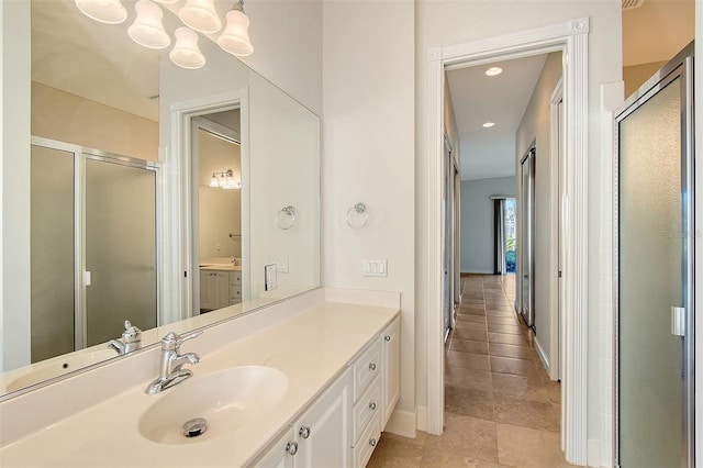 bathroom featuring tile patterned flooring, vanity, and a shower with shower door