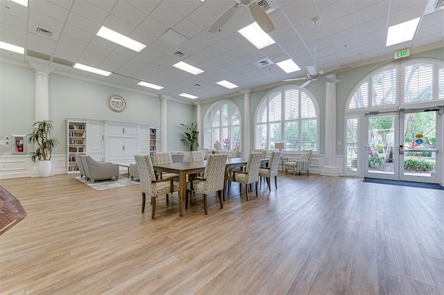 dining area with french doors, a towering ceiling, light hardwood / wood-style flooring, and ceiling fan