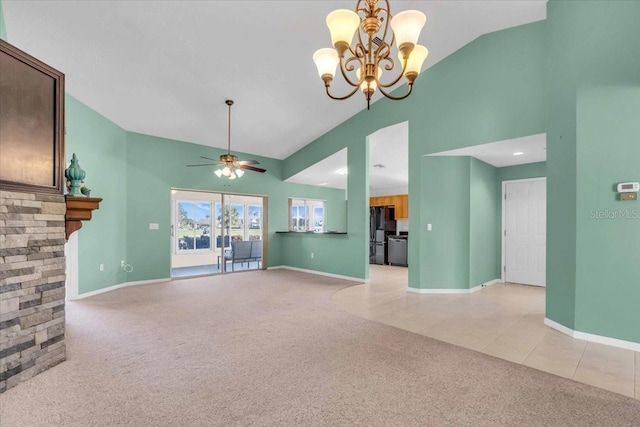 unfurnished living room with light carpet, ceiling fan with notable chandelier, high vaulted ceiling, and a stone fireplace