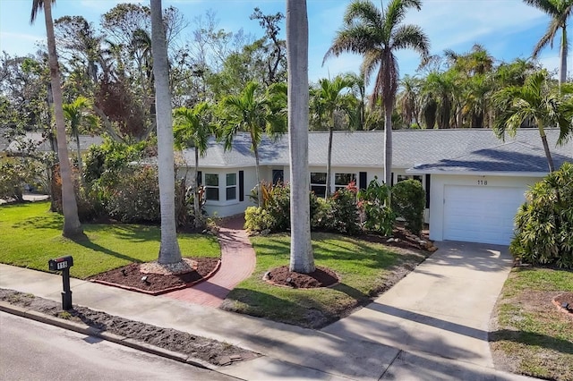 ranch-style house featuring a garage and a front lawn