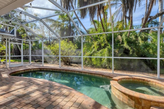 view of swimming pool with glass enclosure, a patio area, and an in ground hot tub