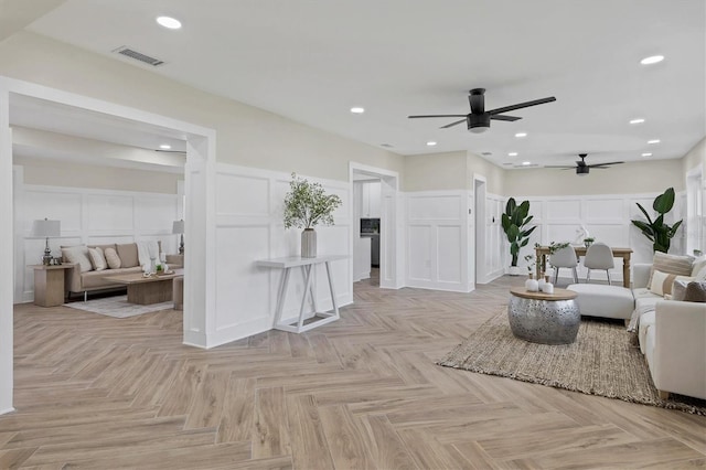 living room featuring light parquet flooring and ceiling fan