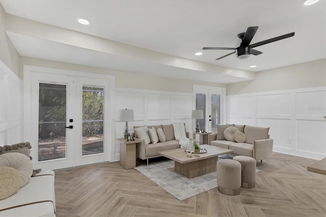 living room with light parquet flooring, ceiling fan, and french doors