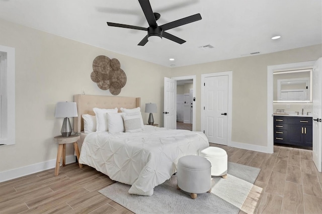 bedroom with ceiling fan, sink, and connected bathroom