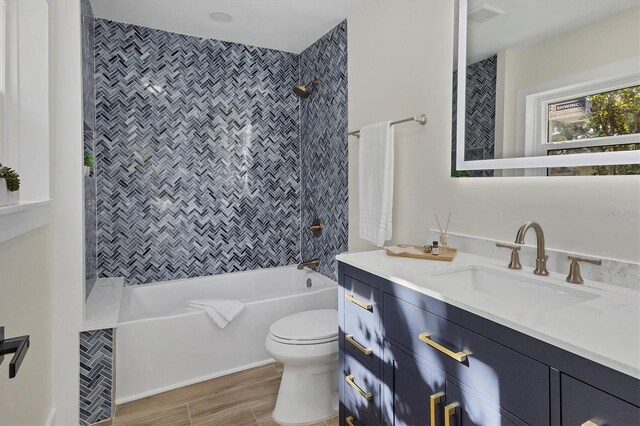 full bathroom featuring vanity, toilet, and tiled shower / bath combo