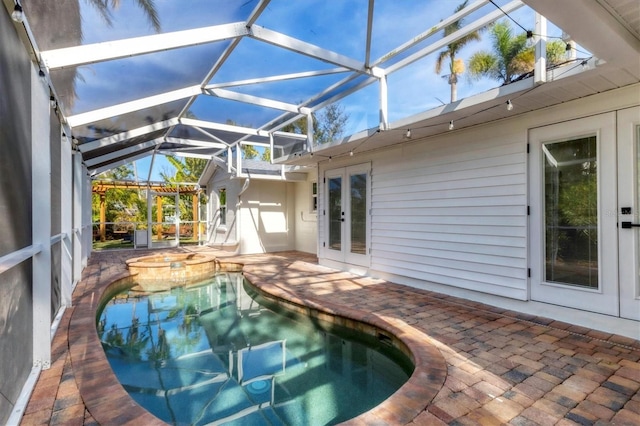 view of pool featuring a patio area, a lanai, an in ground hot tub, and french doors