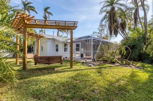 back of property featuring glass enclosure and a lawn