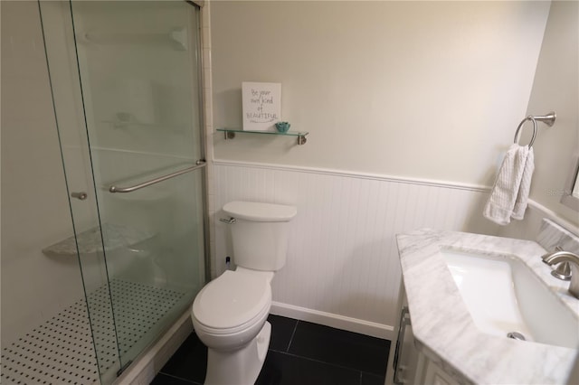 bathroom with toilet, a shower with door, vanity, and tile patterned floors