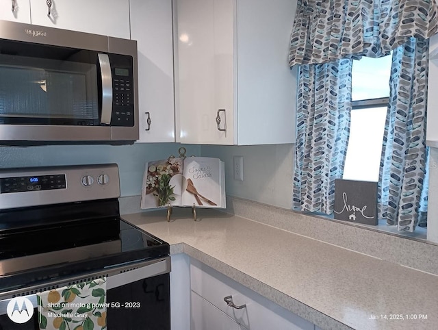 kitchen with appliances with stainless steel finishes and white cabinetry