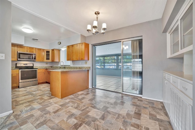 kitchen with light stone countertops, hanging light fixtures, stainless steel appliances, kitchen peninsula, and a chandelier