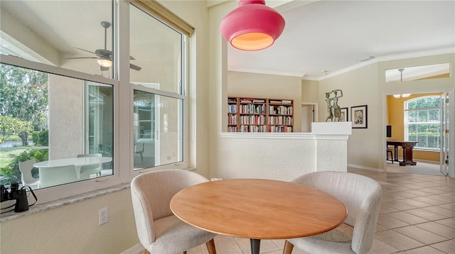 tiled dining space featuring ceiling fan and ornamental molding