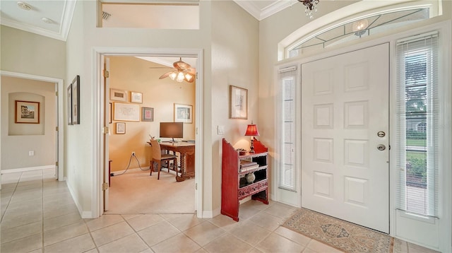 entryway featuring light colored carpet, ceiling fan, and ornamental molding