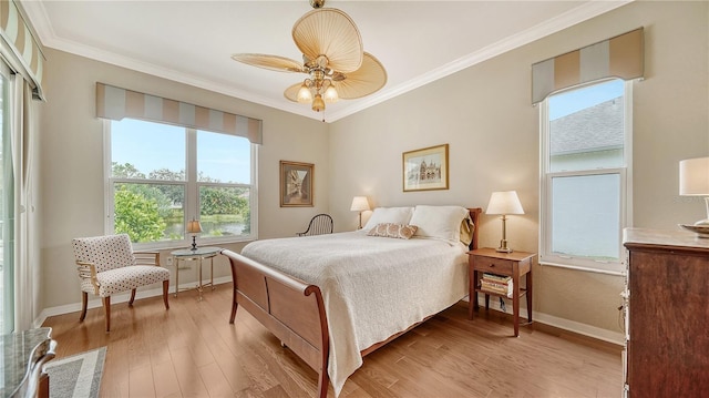 bedroom featuring ceiling fan, light hardwood / wood-style floors, and crown molding