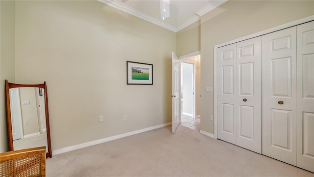 unfurnished bedroom featuring ceiling fan, crown molding, light carpet, and a closet