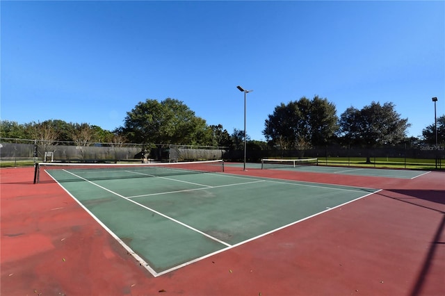 view of tennis court featuring basketball hoop