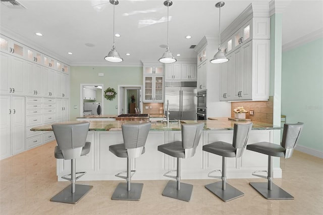 kitchen featuring appliances with stainless steel finishes, a kitchen breakfast bar, hanging light fixtures, and white cabinets