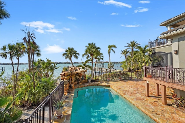 view of pool with a water view and a patio area