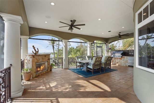 view of patio featuring ceiling fan, area for grilling, and exterior kitchen