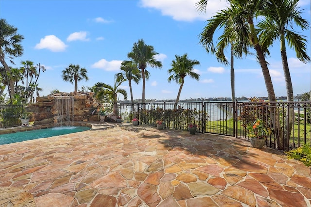 view of patio / terrace featuring pool water feature, a water view, and a fenced in pool