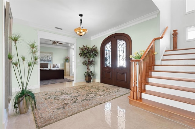 foyer entrance with ornamental molding and french doors