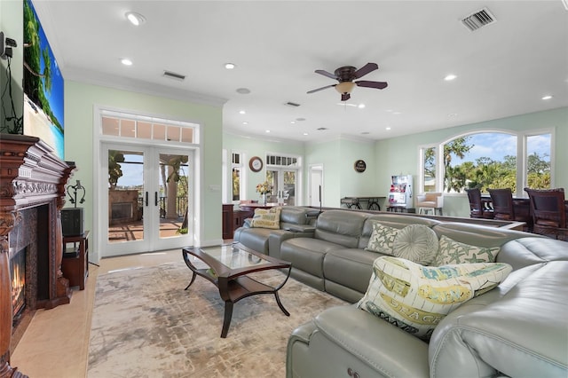 living room featuring ceiling fan, ornamental molding, french doors, and a high end fireplace