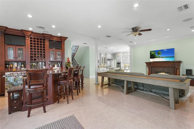 bar with ornamental molding and ceiling fan