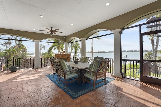 view of patio with a water view and ceiling fan