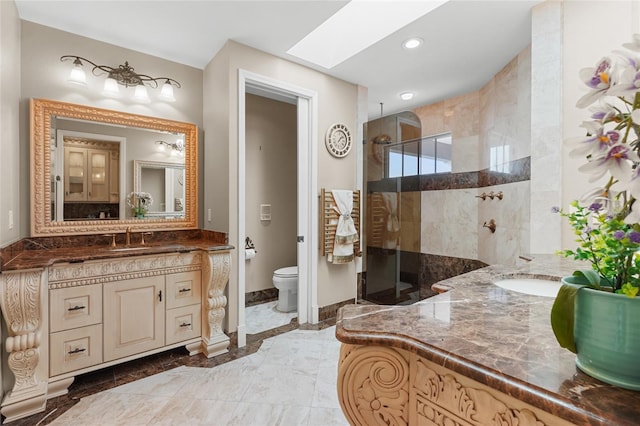 bathroom with vanity, toilet, a skylight, and walk in shower