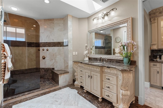 bathroom featuring tiled shower, a skylight, and vanity