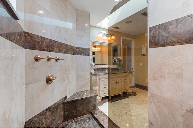 bathroom with vanity, tiled shower, and a skylight