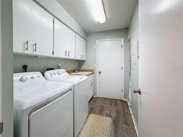 clothes washing area with sink, cabinets, separate washer and dryer, dark hardwood / wood-style floors, and a textured ceiling