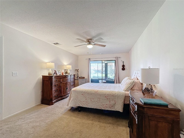 carpeted bedroom featuring ceiling fan and a textured ceiling