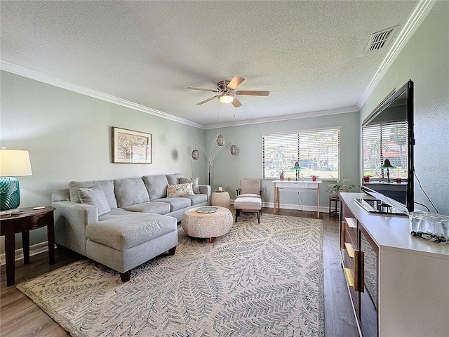 living room featuring hardwood / wood-style floors, a textured ceiling, ceiling fan, and ornamental molding