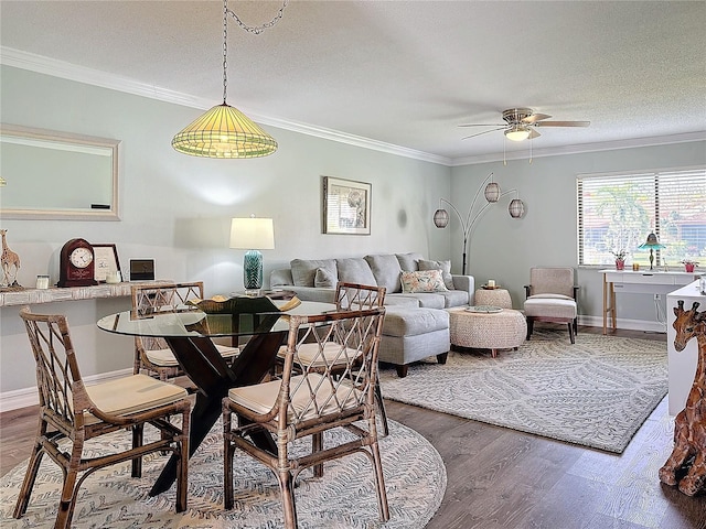 dining room featuring hardwood / wood-style floors, ceiling fan, ornamental molding, and a textured ceiling