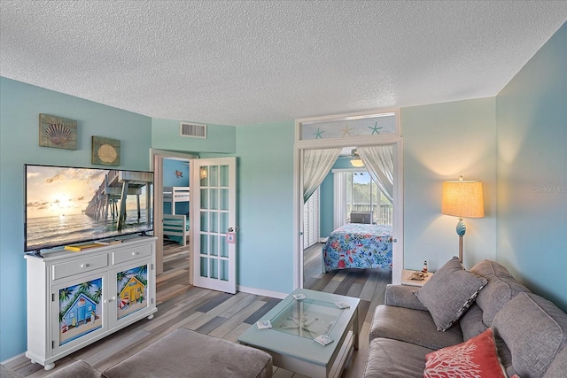 living room with light hardwood / wood-style floors and a textured ceiling