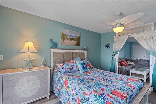 bedroom featuring hardwood / wood-style flooring, ceiling fan, and a textured ceiling