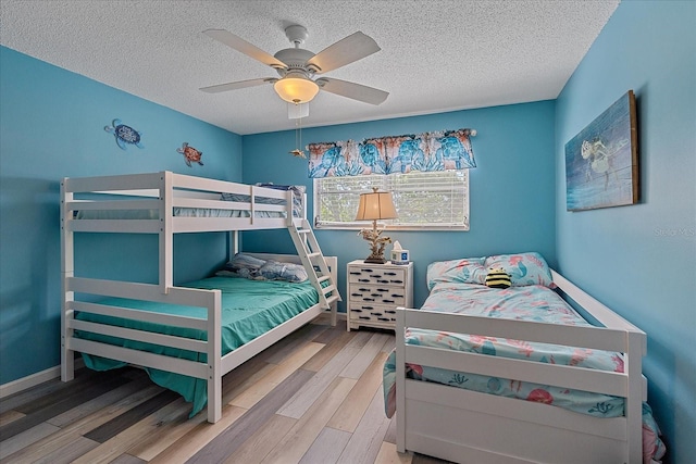 bedroom featuring wood-type flooring, a textured ceiling, and ceiling fan