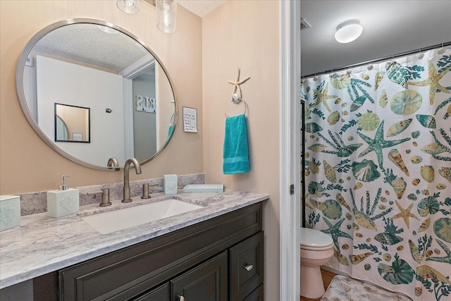 bathroom with curtained shower, vanity, and toilet