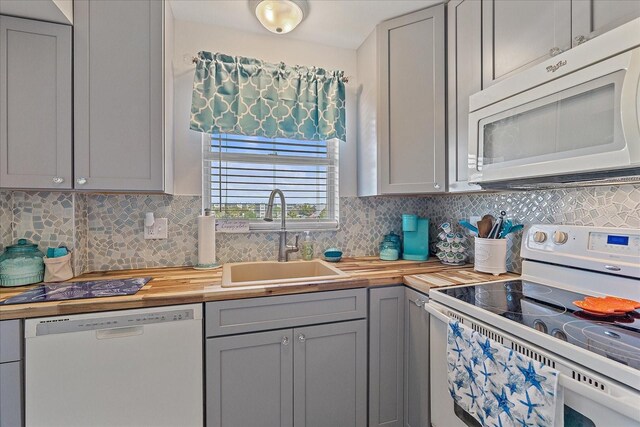 kitchen featuring gray cabinetry, sink, and white appliances