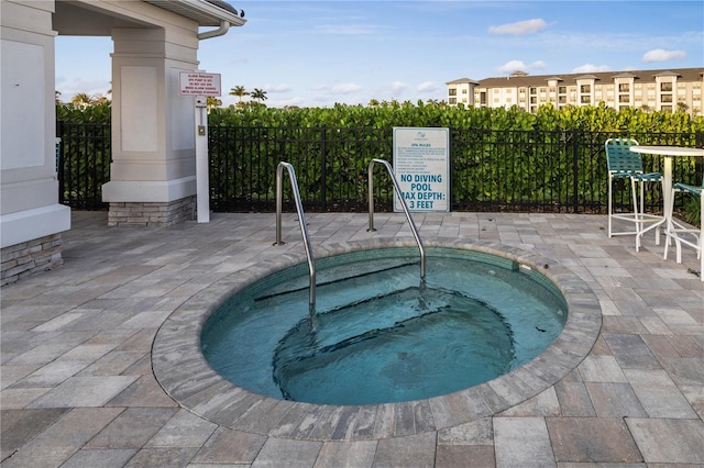 view of swimming pool with a hot tub