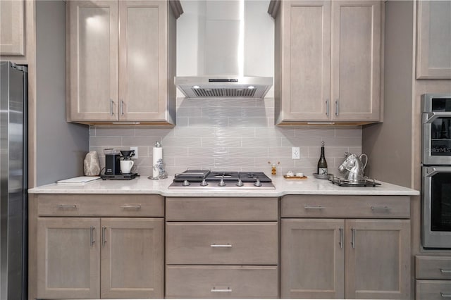 kitchen featuring decorative backsplash, stainless steel appliances, and wall chimney range hood