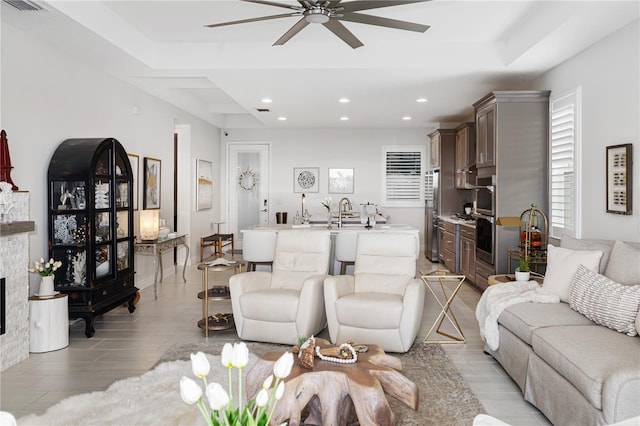 living room featuring ceiling fan and a fireplace