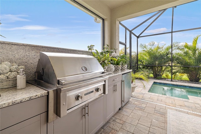 view of patio with an outdoor kitchen, a grill, and a lanai