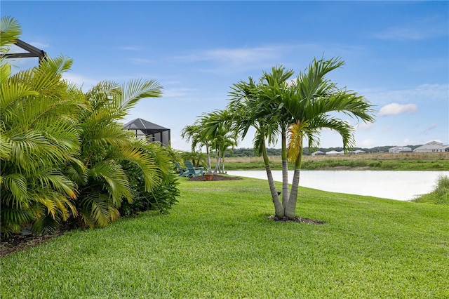 view of yard with a water view and glass enclosure