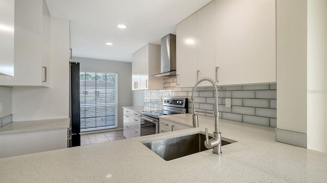 kitchen with white cabinetry, decorative backsplash, and wall chimney exhaust hood