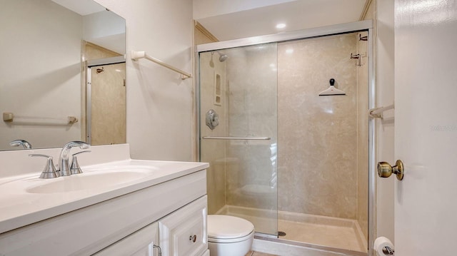 bathroom with vanity, toilet, and a shower with door