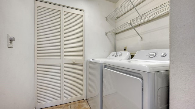 laundry area featuring washer and clothes dryer and light tile patterned flooring