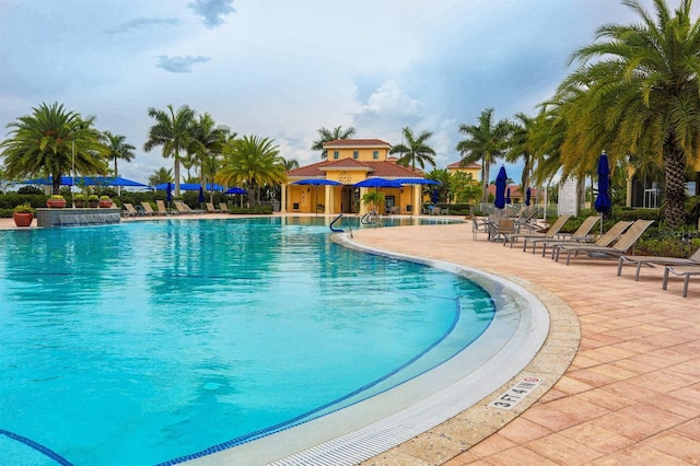 view of pool featuring pool water feature and a patio