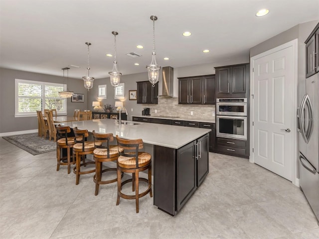 kitchen featuring pendant lighting, a breakfast bar, a spacious island, sink, and stainless steel appliances